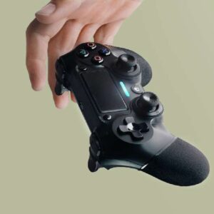 The hand holds a black gamepad for playing computer games