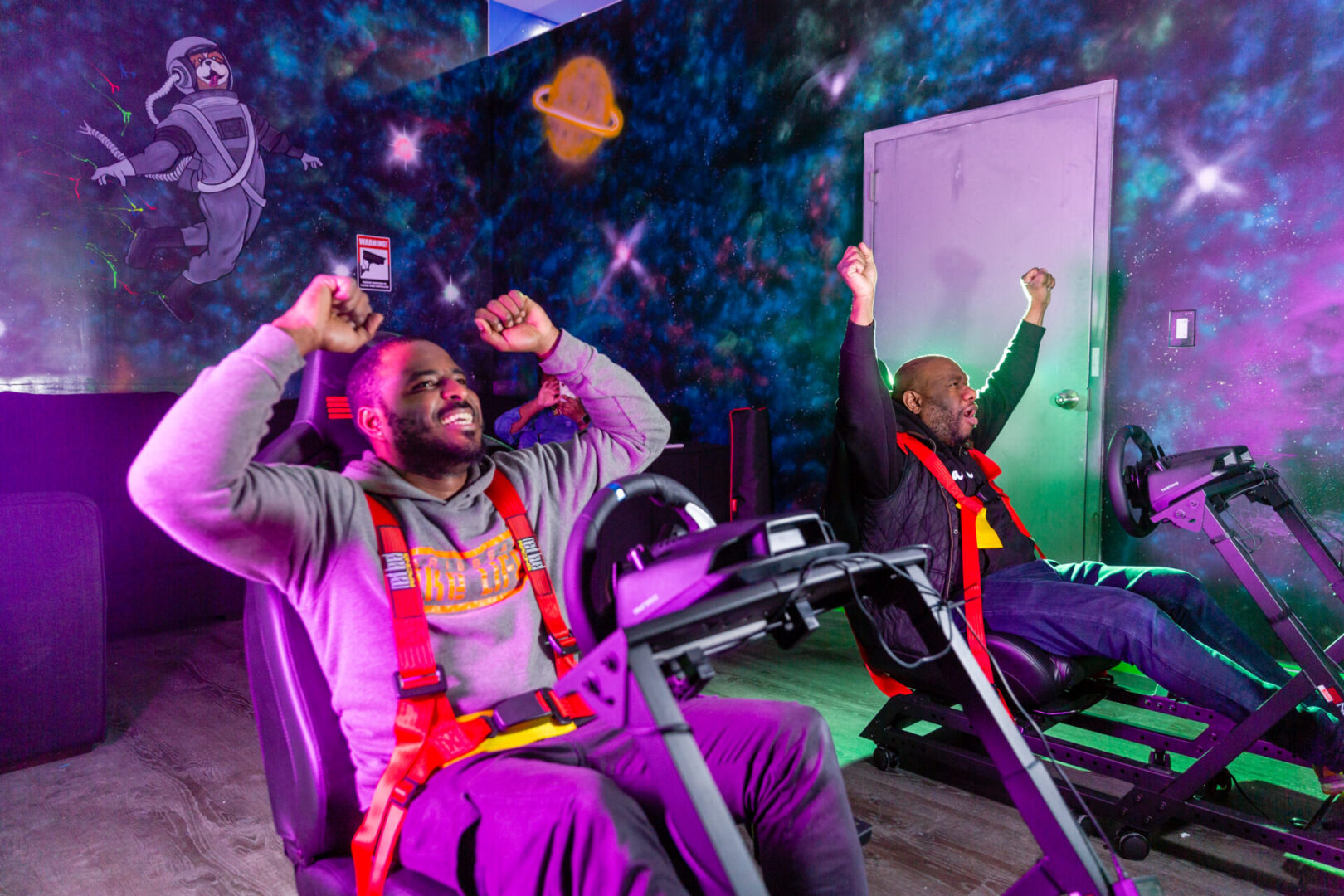 two men sitting on the gaming chairs and cheering