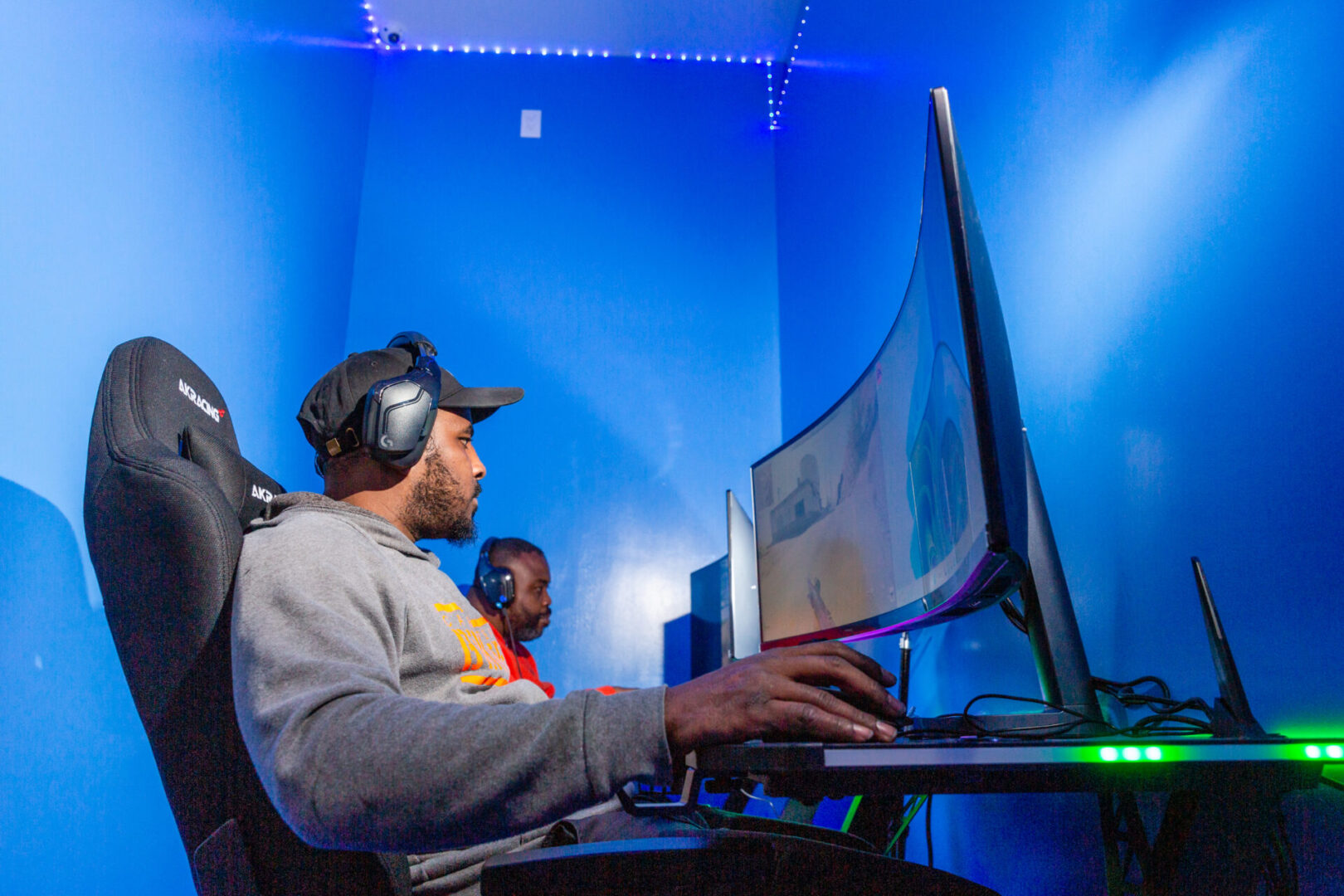 a man wearing headphones and cap is playing a game